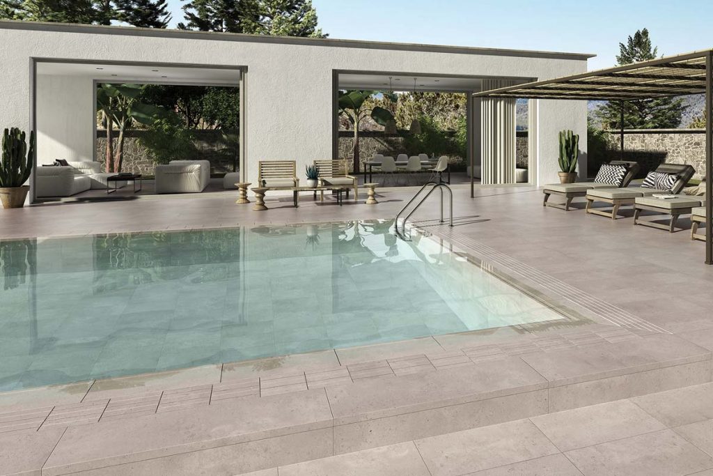 Outdoor beige stone effect tiles near swimming pool.