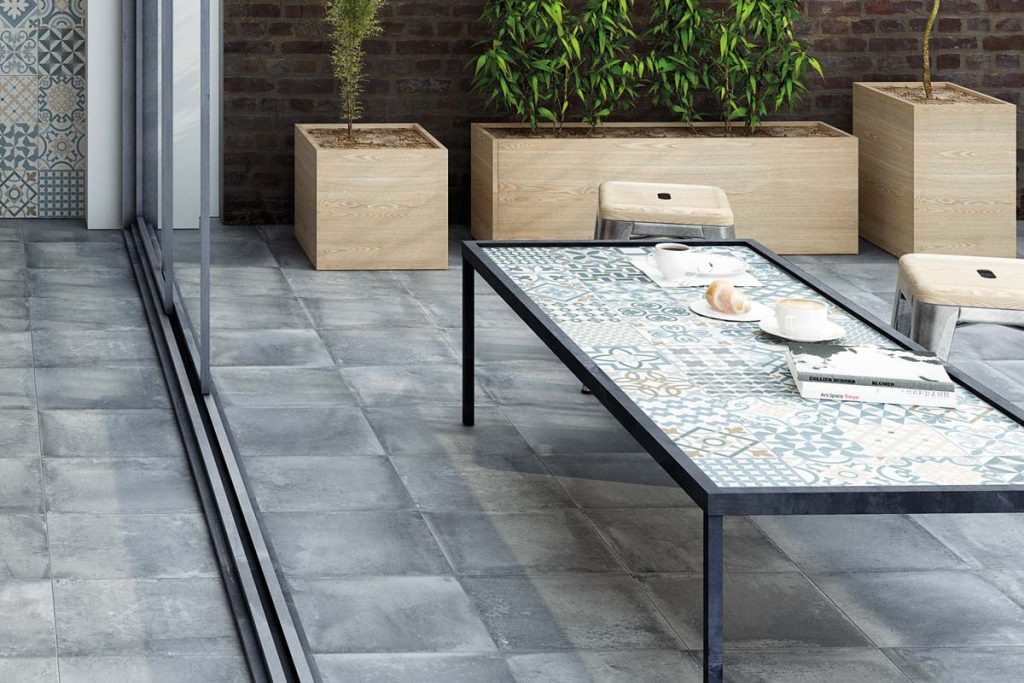 Outdoor grey stone effect tiles with outdoor seating.