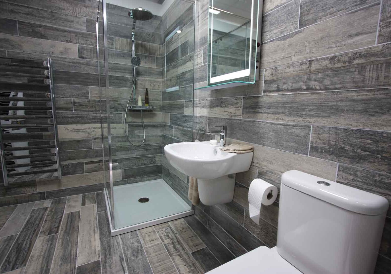 Bathroom tiles with sink and shower.